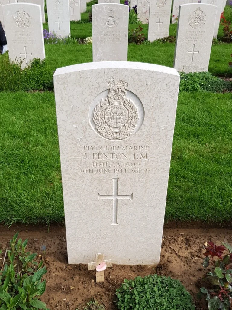 Photo of a single gravestone, with more visible behind