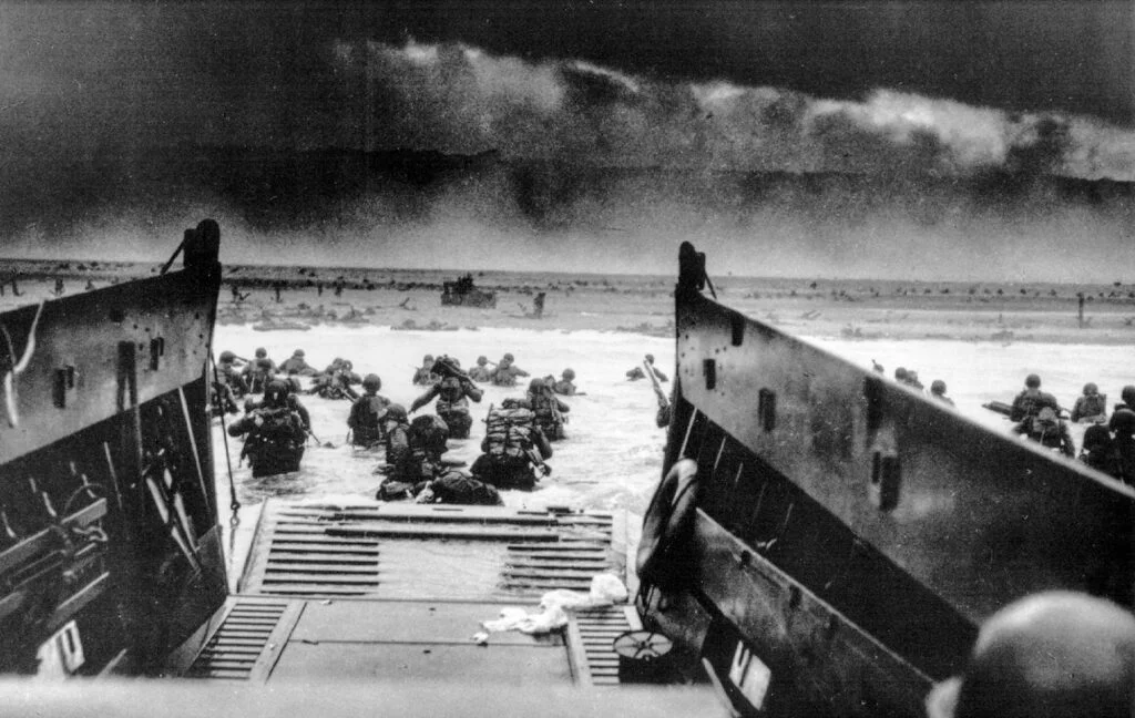 View from inside an LCVP landing craft on D-Day as troops struggle ashore towards the beach.