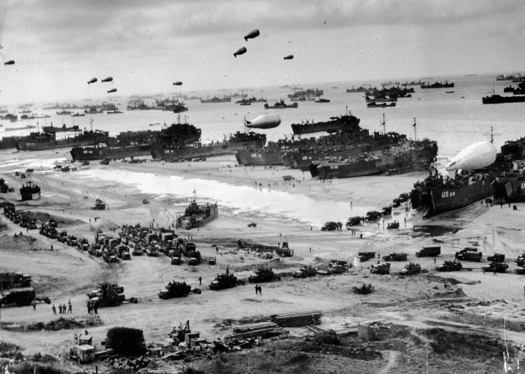 View over a beach seen from above, with many ships drawn up along the shore.