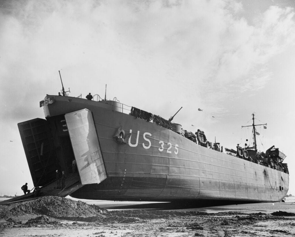 A Landing Ship, Tank on a beach with its bow resting on a pile of sand
