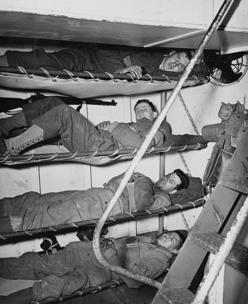 Men lying in bunks on four levels, on board a ship